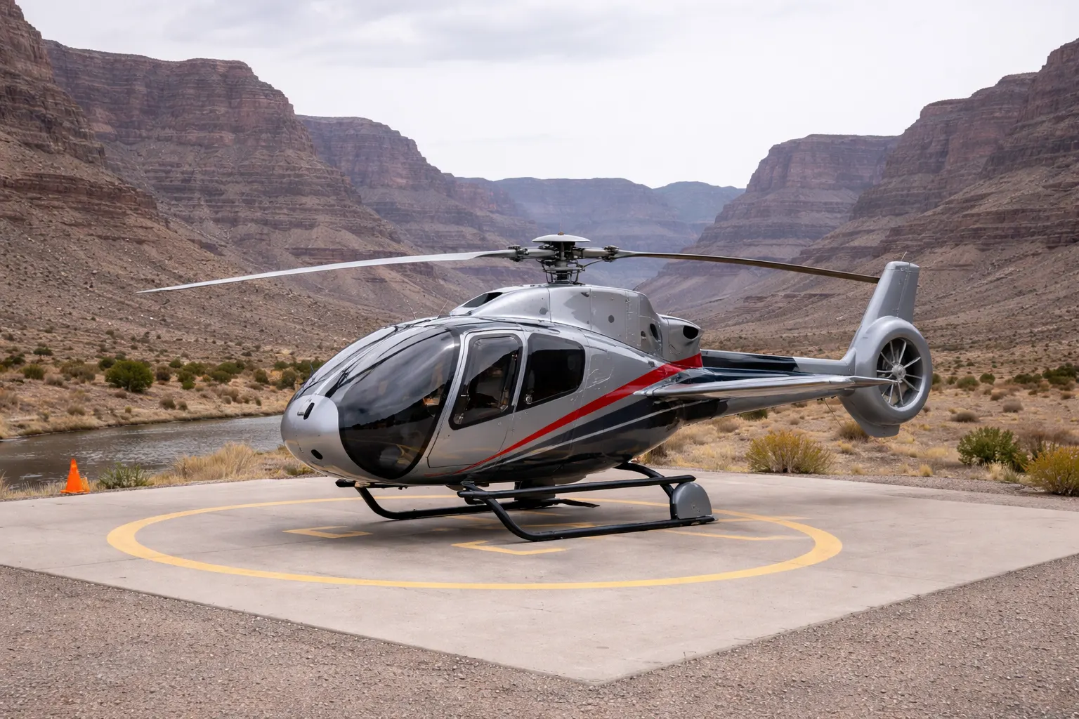 Airbus Helicopters EC130 tour helicopter on a helipad in a desert canyon environment