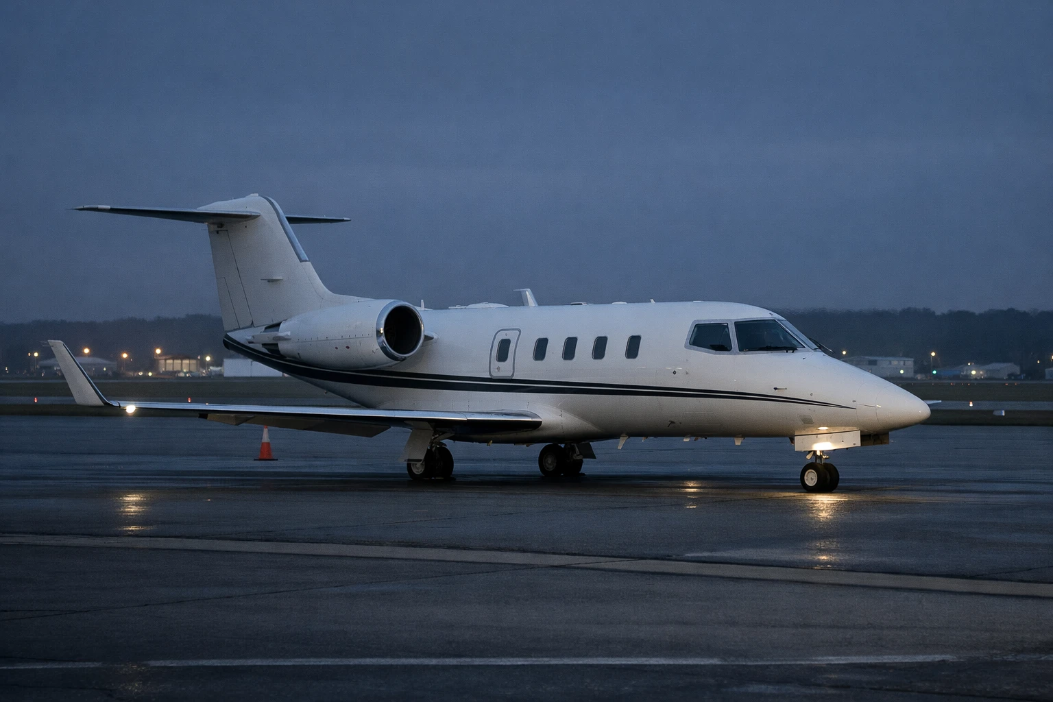 Learjet 55 business jet on an airport ramp in a night-to-dawn setting