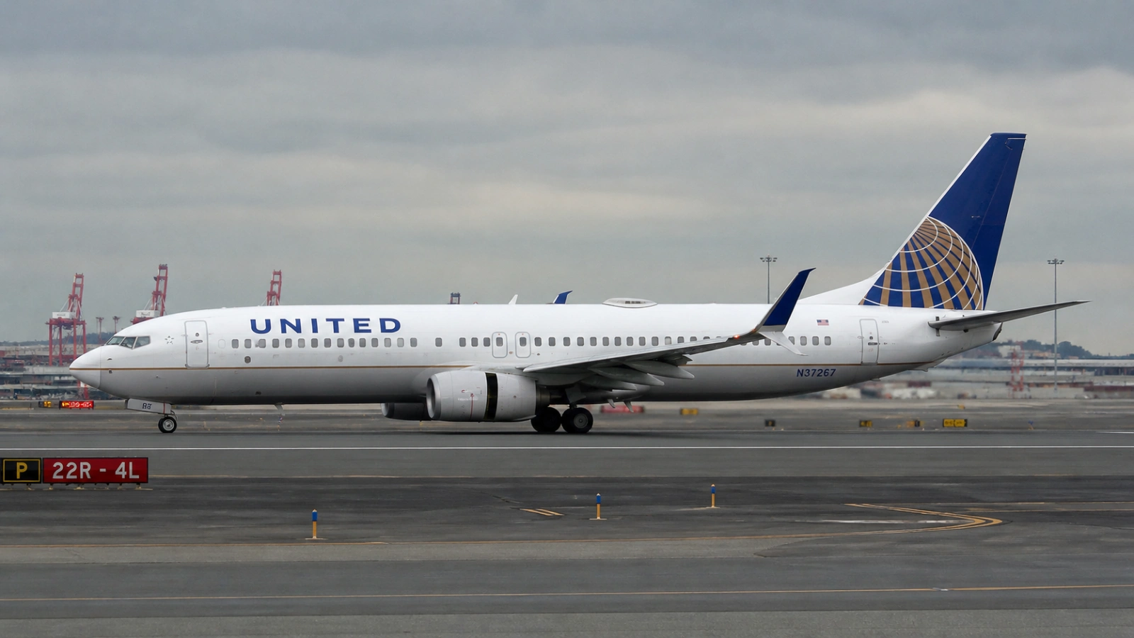 United Airlines Boeing 737 on runway at Newark Liberty International Airport with runway lighting visible