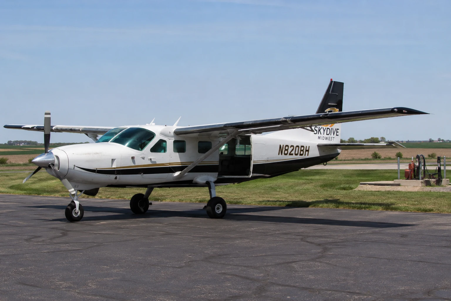 Single-Engine Turboprop Skydiving Aircraft at a Rural Airfield Single-engine turboprop skydiving aircraft parked on a rural airfield under clear daylight